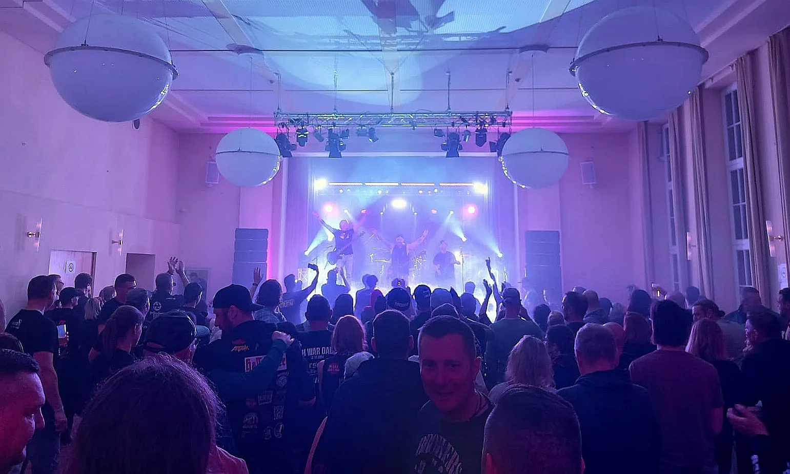 Gut gefüllter Saal des Kulturhauses im violetten Bühnenlicht